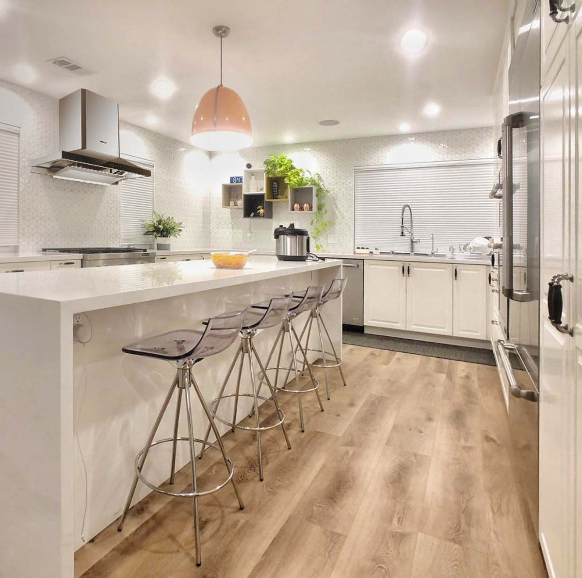 EMS9026 range hood mounted on the wall in a modern white kitchen.