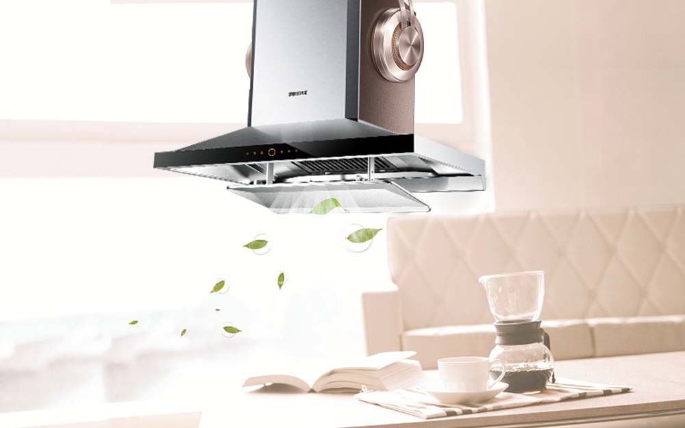 Stylized image of the EMS9026 stainless steel range hood above a book and cup of coffee.