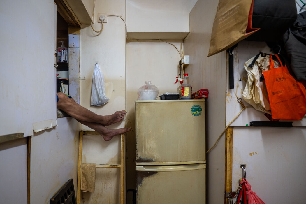 去年,一名男子在香港一间被称为“棺材房”的分割单位里休息。